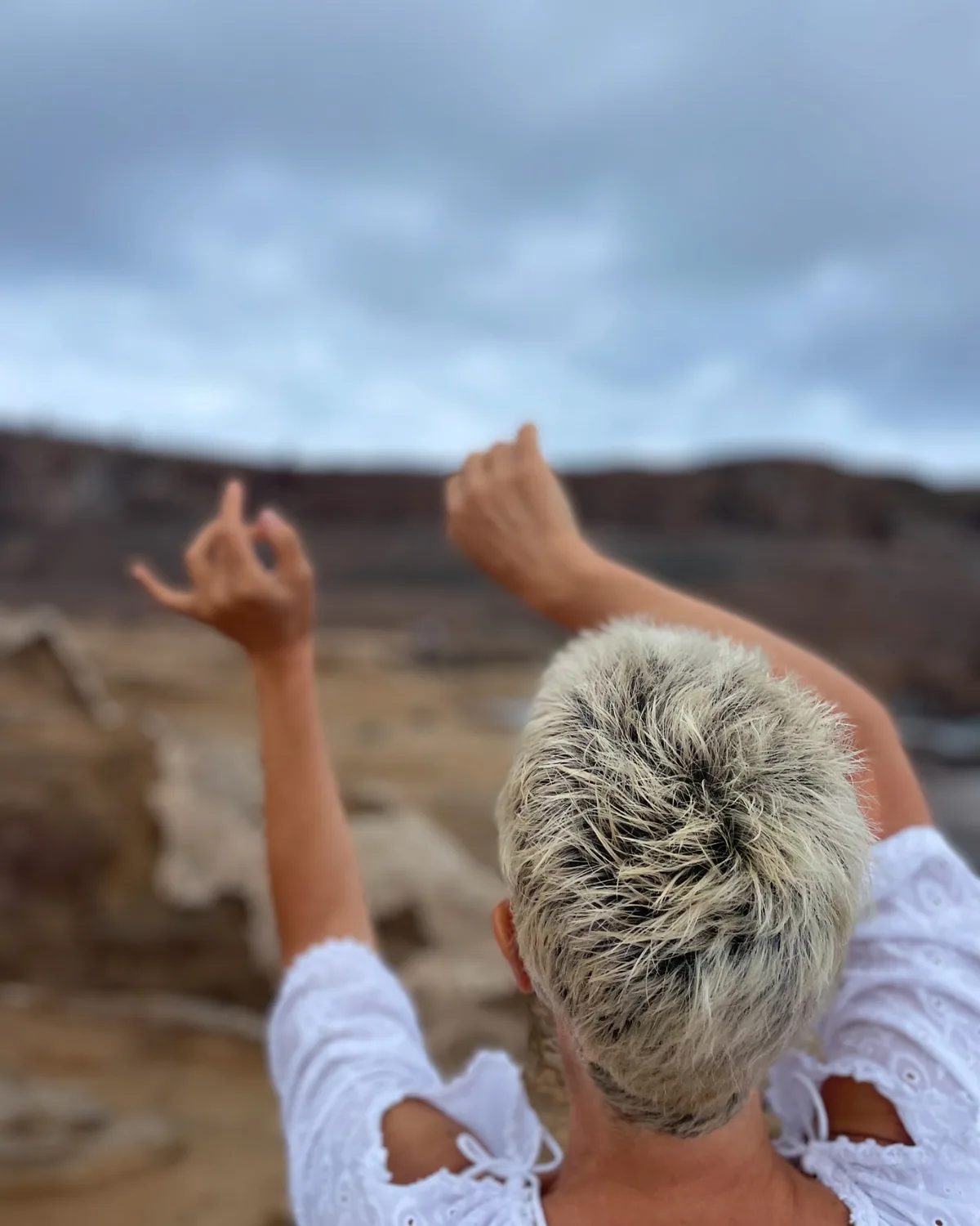 Masajista de espaldas junto al paisaje costero de Gran Canaria